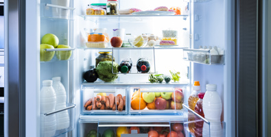 Photo of an open open french-doored fridge. The fridge is filled with fresh produce