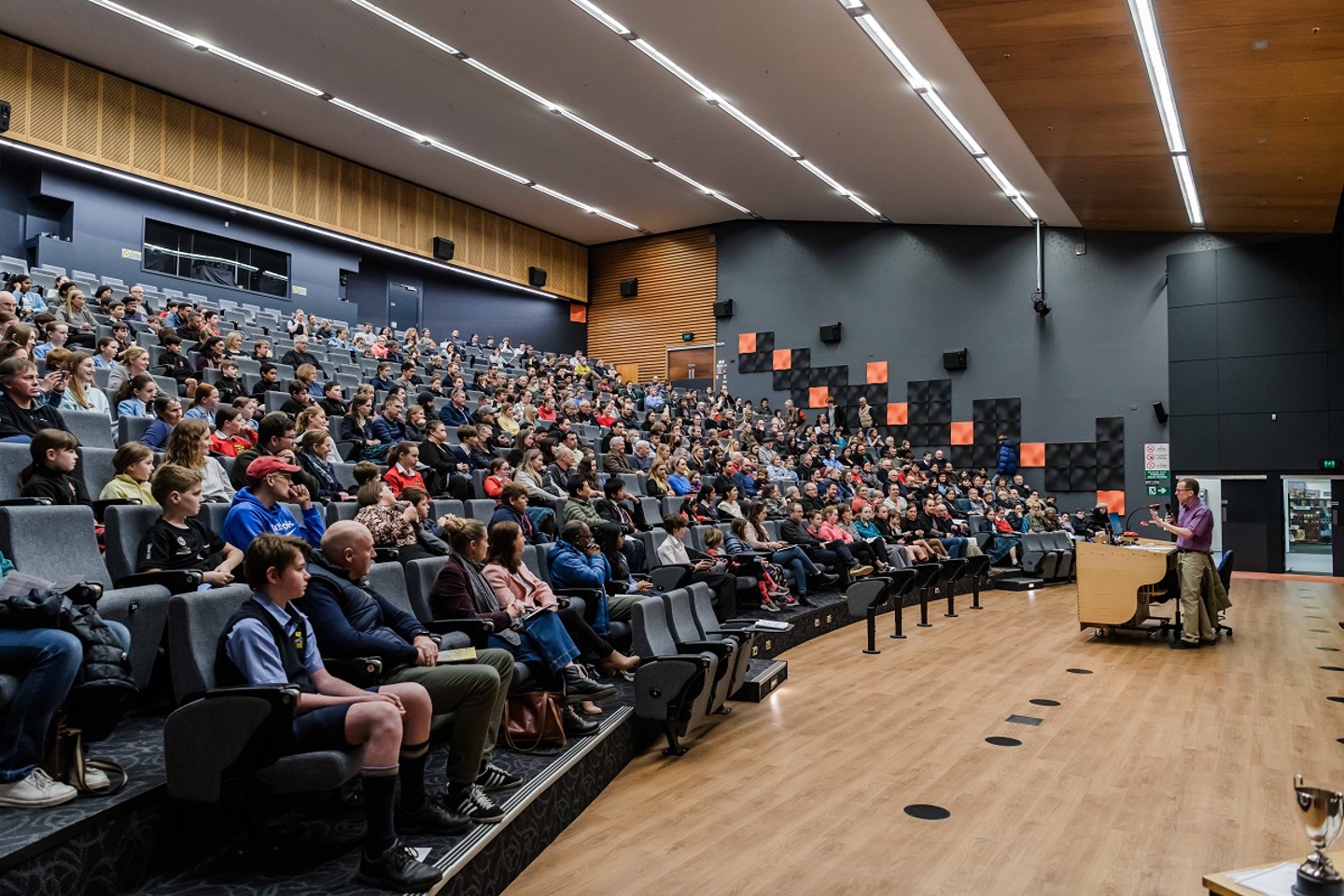 Students sitting in the auditorium at a prize giving event.