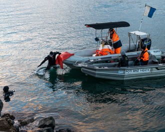 divers getting off boats and into the water
