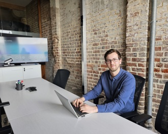Man sitting at desk typing on laptop