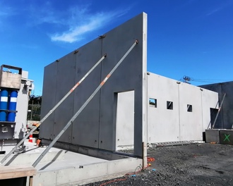 Photo shows the transformer in place next to the prefabricated concrete walls that are the beginnings of the new substation area.