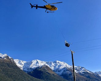 Helicopter installing power lines over Dart River