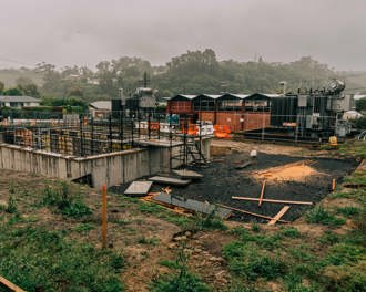 Image shows construction progress at the Anderson's Bay substation from December 2022. Concrete foundations have been laid, there is a crane in the background toward the left the original substation is also in the background.